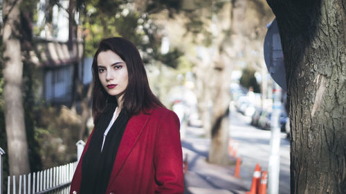 Beautiful young woman looking away while standing in city