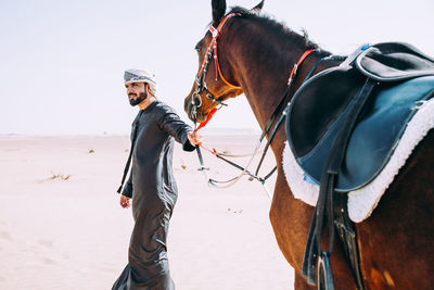 Man with horse on desert