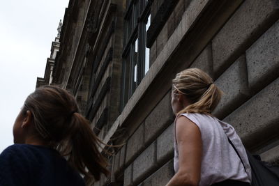 Rear view of mother and daughter in city