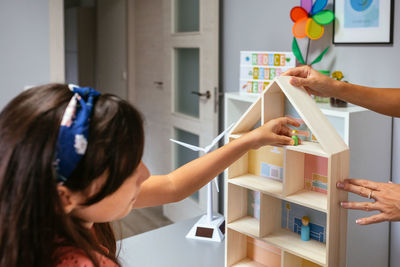 Student in an ecology classroom placing dolls in a house