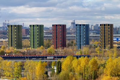 Scenic view of river by city against sky