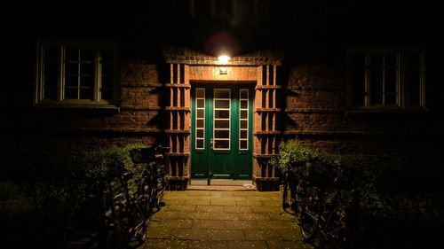 Illuminated footpath by building at night