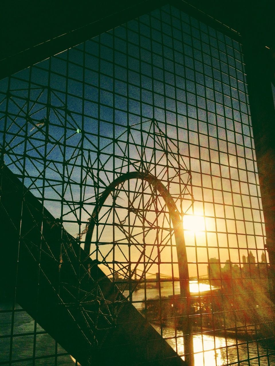 sun, sunlight, built structure, sunbeam, indoors, lens flare, architecture, low angle view, metal, pattern, sunset, sky, fence, railing, glass - material, no people, window, protection, reflection, metal grate