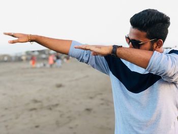 Man dabbing while standing on beach