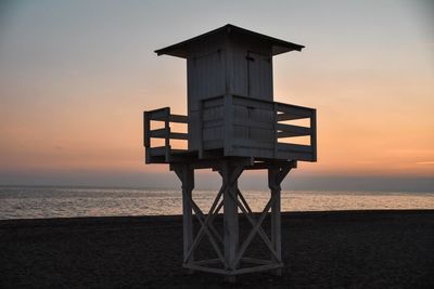 Lifeguard hut on beach during sunset