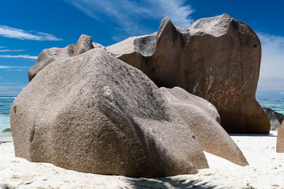 Rock formations on beach against sky