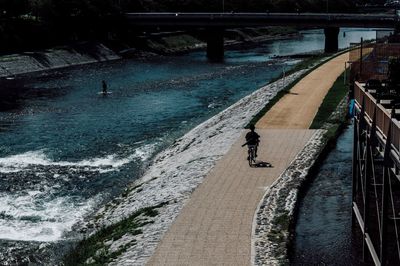 High angle view of man with dog walking on bridge over river