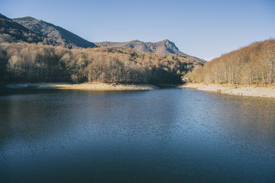 Scenic view of lake and mountains against clear sky