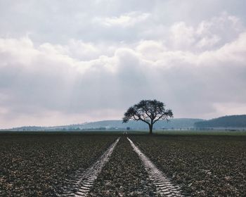 Road amidst field against sky