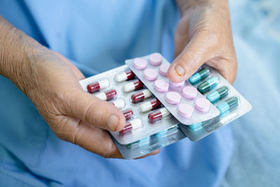 Midsection of man holding pills