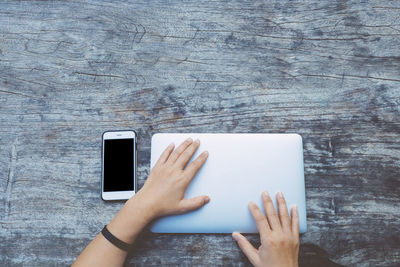 Midsection of person using smart phone on table
