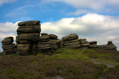 Stack of rocks on landscape against sky