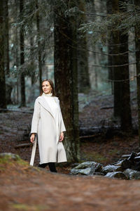 Portrait of woman standing in forest