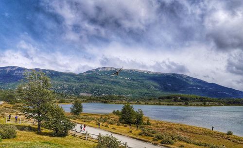 Scenic view of lake by mountains against cloudy sky at tierra del fuego national park