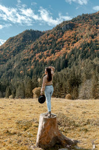 Rear view of young woman standing in valley in autumn, fall, nature, outdoors.