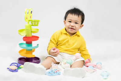 Portrait of boy playing with toy blocks against white background