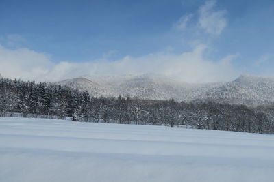 Snow covered landscape against sky