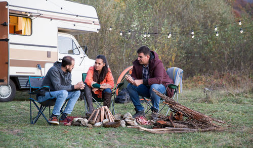 Side view of young friends working on field