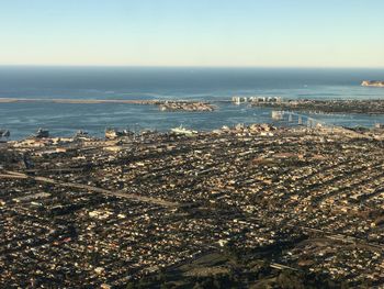 Aerial view of sea and buildings against sky