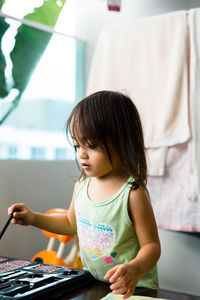 Cute girl holding paintbrush