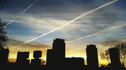 Low angle view of silhouette buildings against sky at sunset