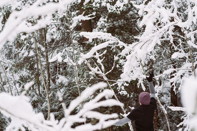 Man jumping by snowy tree