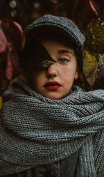 Portrait of girl in fall leaves red lipstick and large knitted scarf