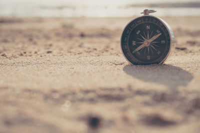 Close-up of compass on sand