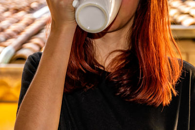 Midsection of woman drinking coffee