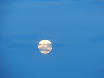 Low angle view of moon against blue sky at night