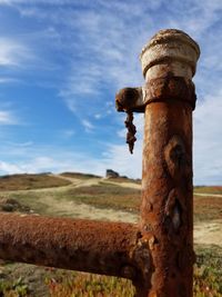 Close-up of rusty metal against sky