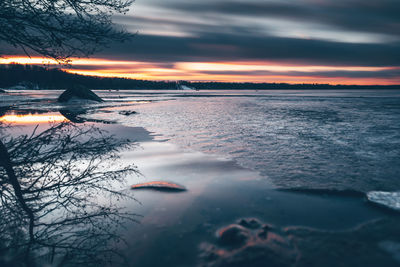 Scenic view of lake against sky during sunset during winter