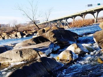 Bridge over river against sky during winter