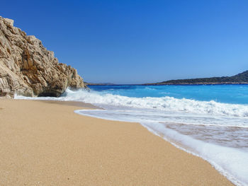 Scenic view of beach against clear blue sky