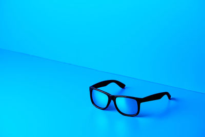 Close-up of eyeglasses on swimming pool against clear blue sky