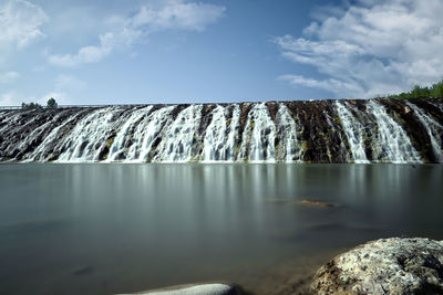 Panoramic view of waterfall against sky