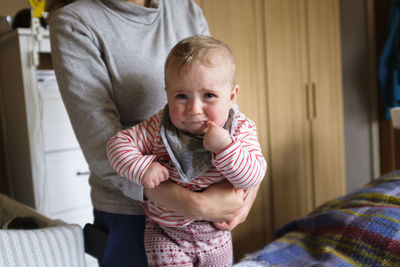 Mother and baby on bed at home