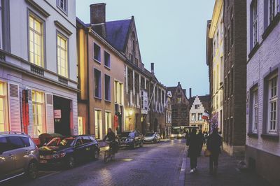 Cars on street in city against sky