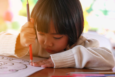 Close-up portrait of cute girl holding table