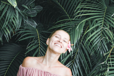 Portrait of smiling young woman against plants