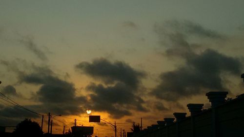 High section of silhouette building against sky at sunset