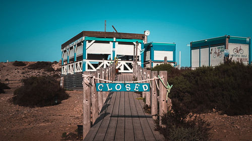 Information sign on land against clear blue sky