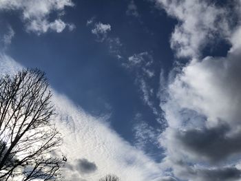 Low angle view of bare tree against cloudy sky