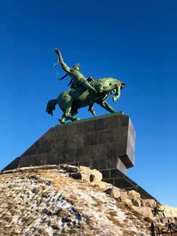 Low angle view of statue against blue sky