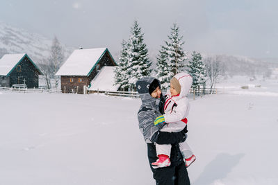 Full length of woman walking on snow covered field