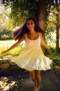 Happy young woman dancing on field