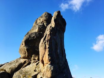 Low angle view of rock formation against blue sky