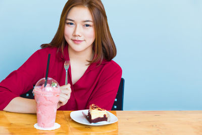 Portrait of young woman sitting at table