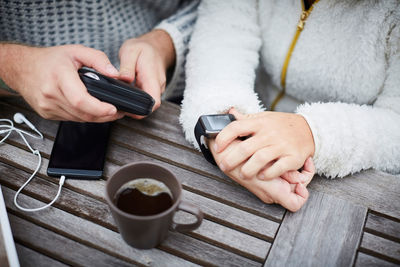 High angle midsection of caretaker and disabled woman using technologies at table