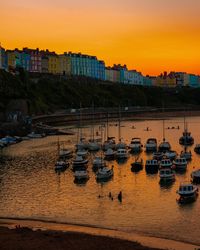 High angle view of sailboats at harbor during sunset